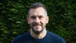 Colour head and shoulders photo of Paul Wilson smiling at the camera