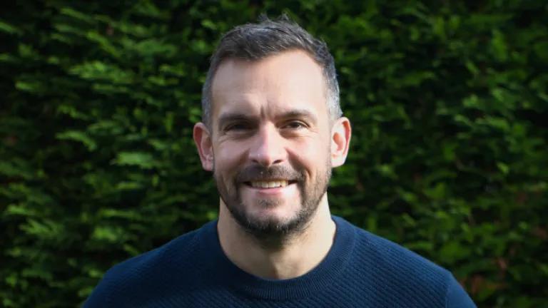 Colour head and shoulders photo of Paul Wilson smiling at the camera