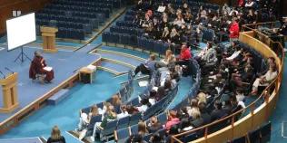 Colour birds eye view photo of Discovery Day 2024 attendees sat in the Assembly Hall listening to Dr Upali Sraman as he speaks to them