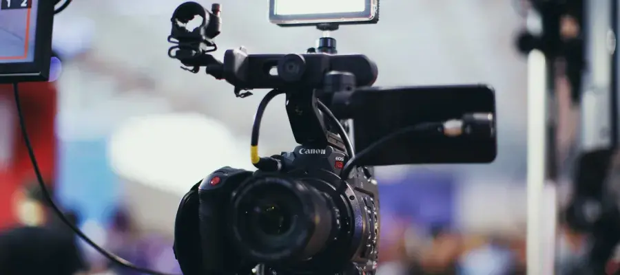 Colour photo of a camera on a tripod.