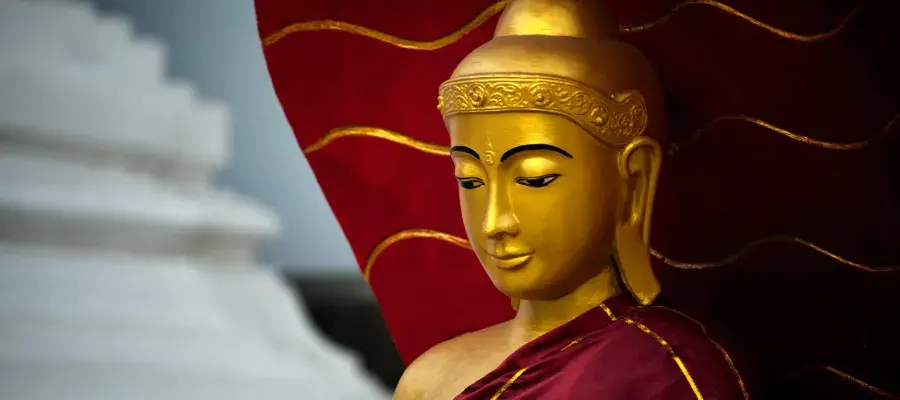 Colour image of the head of a red and gold statue of the Buddha