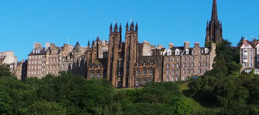 Colour photo of the New College building sitting atop the mound in Edinburgh surrounded by other buildings in the Edinburgh skyline