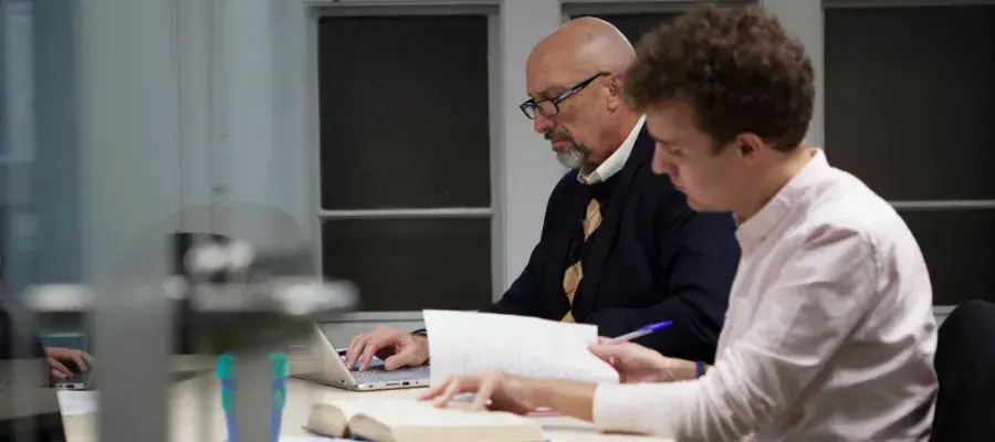 Colour photo of two students studying in the Blackie MacKinnon postgraduate masters study room