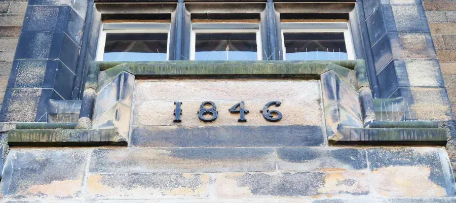 Colour photo of the front of the New College building with numbering reading '1846' the year when New College was built