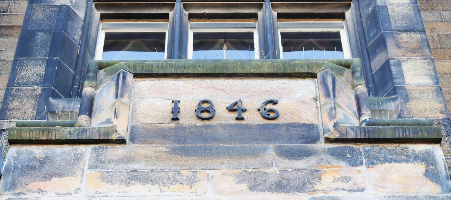 Colour photo of the front of the New College building with numbering reading '1846' the year when New College was built