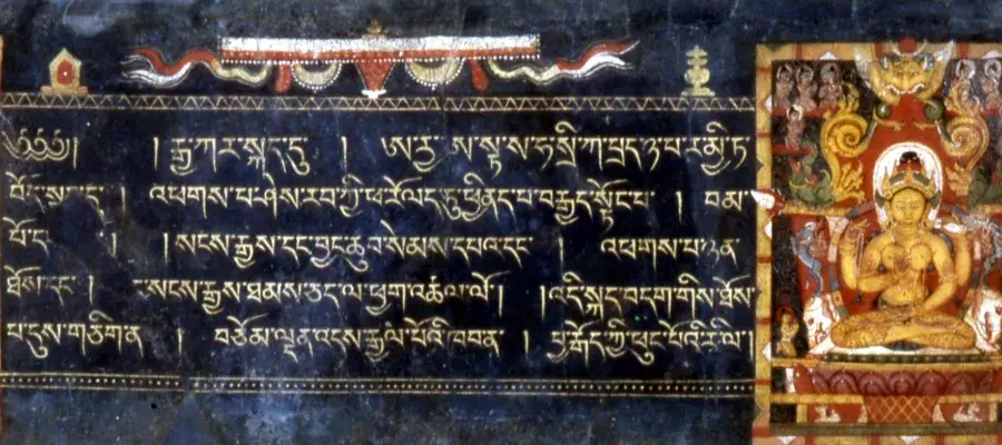 Colour photo of a language written on a textured background. Images of the Buddha are visible to the left and right hand side of the text