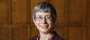 Colour head and shoulders photo of Professor Rachel Muers smiling at the camera