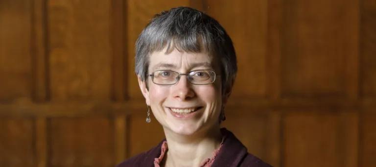 Colour head and shoulders photo of Professor Rachel Muers smiling at the camera