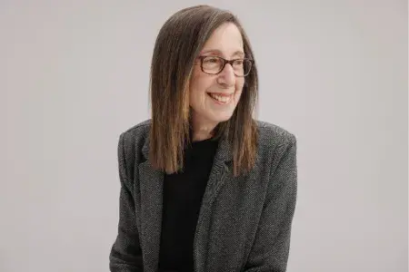 Colour head and shoulders photo of Manya Wilkinson smiling