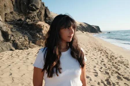 Colour head and shoulders photo of Alycia Pirmohamed looking off into the distance towards the right side of the screen