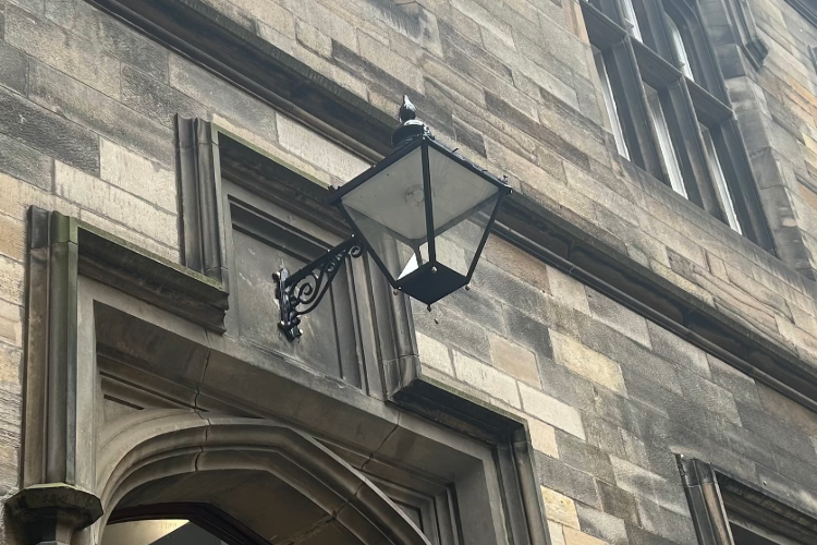Colour photo of the cast iron lights in the New College Quad hanging over the entrance doorway