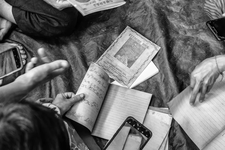 Black and white photo of community members handling notebook replicas