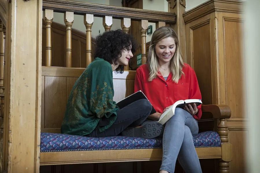 Colour photos of students sitting, smiling, and reading together in New College