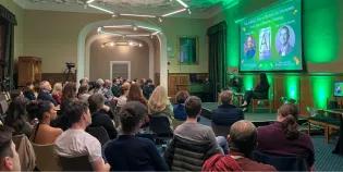 Colour photo of people sat in the Martin Hall watching as Jeremy Carrette and Shannon Vallor talk whilst sat on seats on the stage in the hall