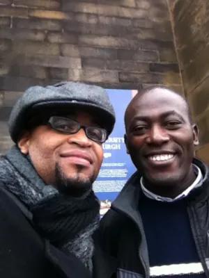 Colour head and shoulders photo of Eric Lewis looking at the camera with a friend