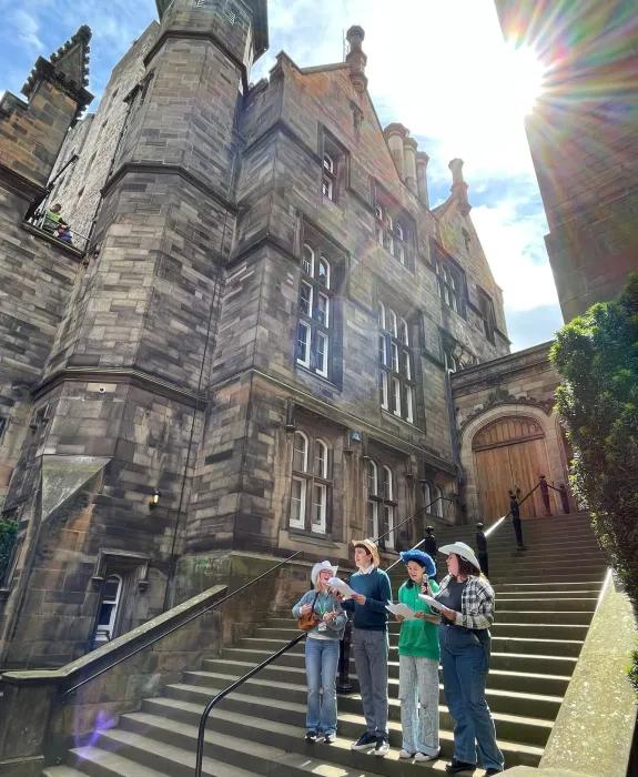 Colour photo of members of the New College Choir stood on the steps in the New College Quad as they perform at the 2024 Discovery Day