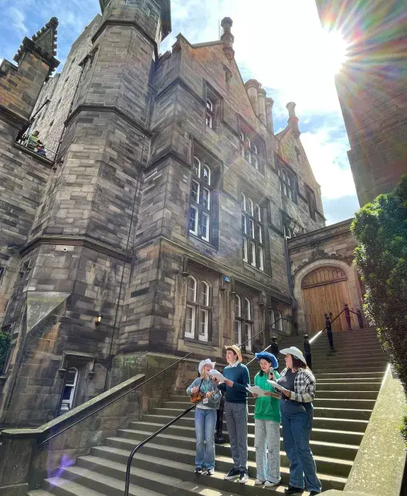 Colour photo of members of the New College Choir stood on the steps in the New College Quad as they perform at the 2024 Discovery Day