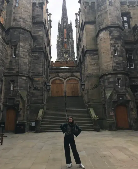 Colour photo of Eliza Light stood smiling at the camera in the New College Quad