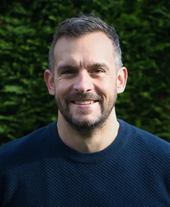 Colour head and shoulders photo of Paul Wilson smiling at the camera