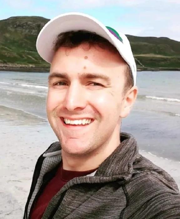 Colour head and shoulders photo of Euan Meston smiling at the camera