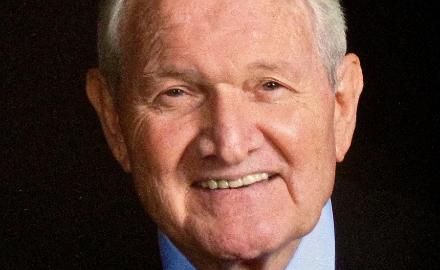 Recent head shot of Lee McDonald in suit and toe against a dark background