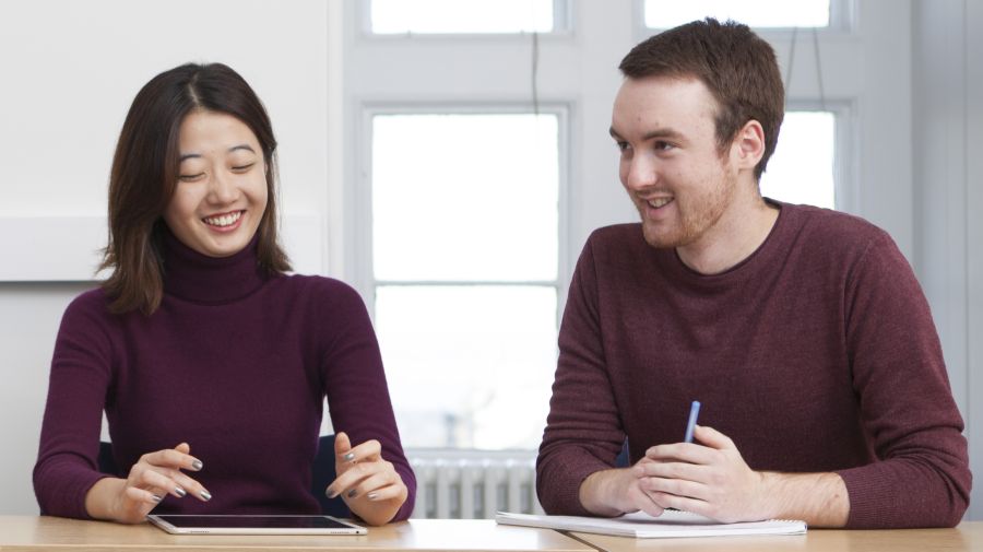 Divinity students Consuella Zhao and Euan Nicoll sitting at a table in a tutorial