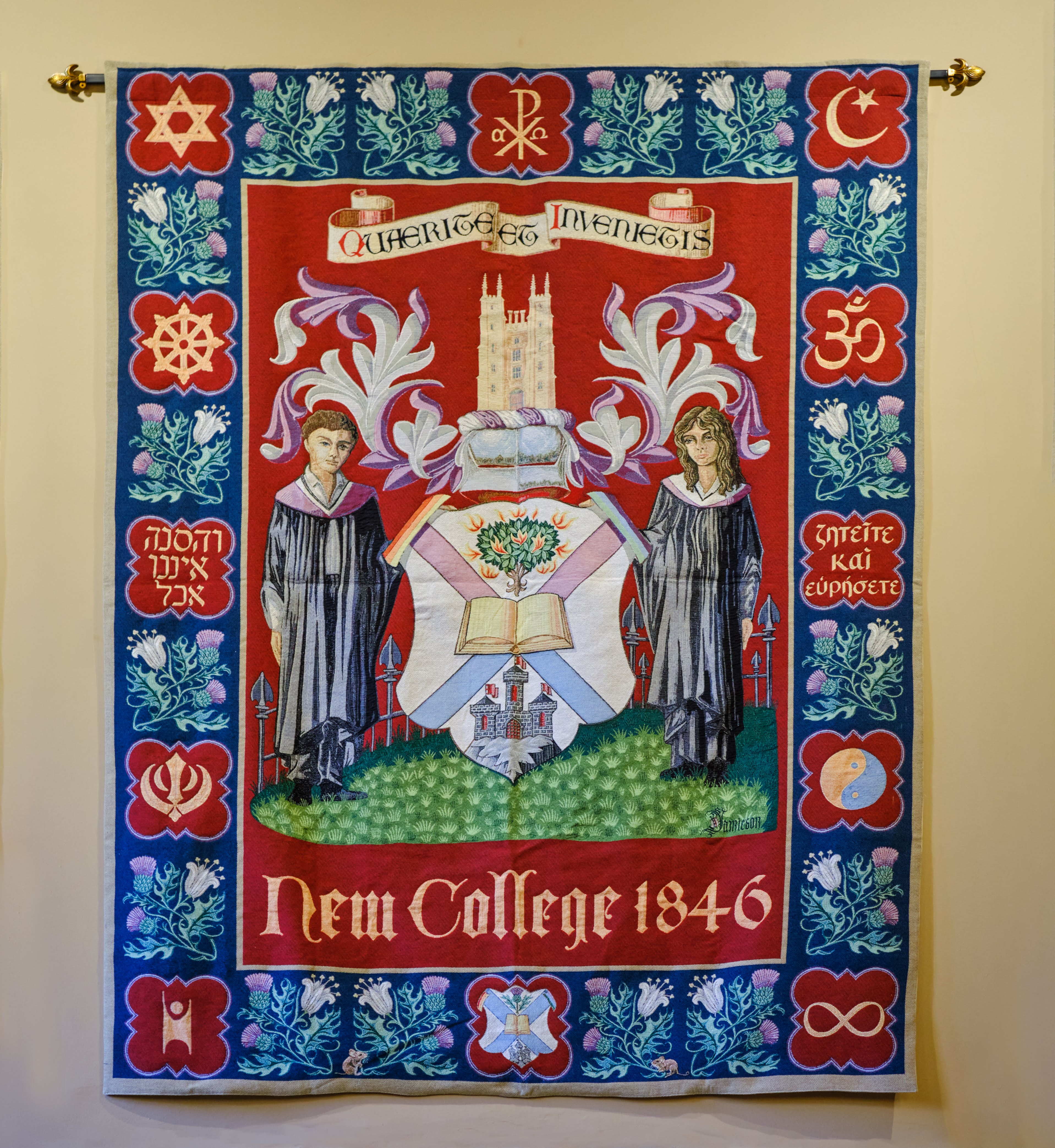 Colour photo of the New College Coat of Arms tapestry hanging up in the Rainy Hall